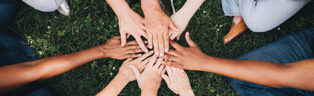 A group of people with hands in the middle